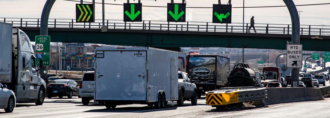 Cars and trucks sitting in traffic on a highway.