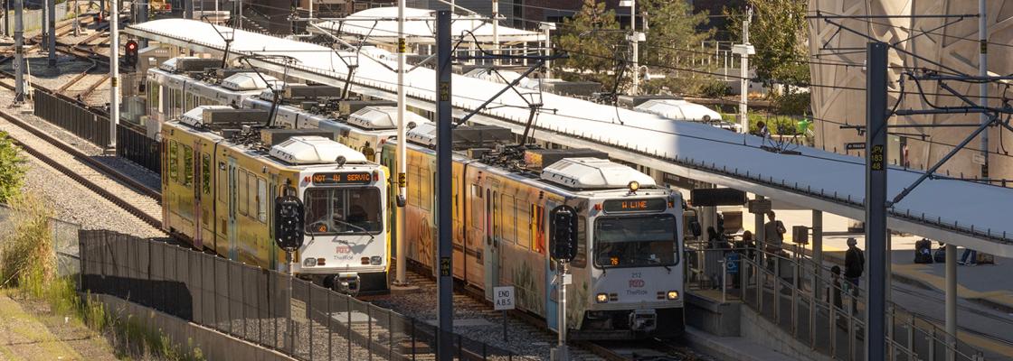 Two light rail trains waiting on the tracks at Union Station in Denver.