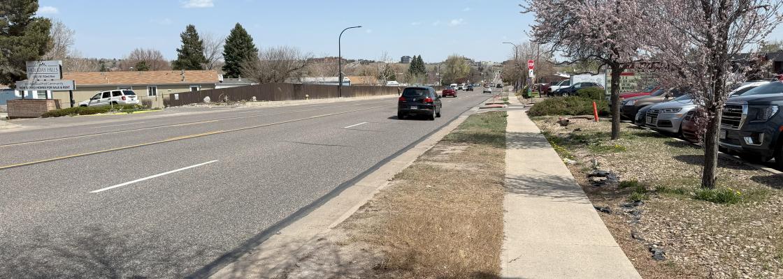 Cars driving down 92nd Avenue during the day